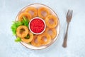 Calamari rings plate. Deep fried squid rings with ketchup and green salad leaves