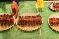 calamari skewers served on plates by a male hand in Tokyo, Japan