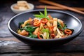 calamari and vegetable stir-fry in black asian bowl