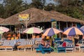 Caucasian tourists relaxing on the beach beds of a restaurant shack on a beach in Goa Royalty Free Stock Photo