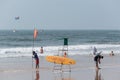 Lifeguards putting up warning flags for safety at high tide at the popular tourist beach in Royalty Free Stock Photo