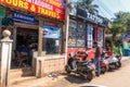 CALANGUTE, GOA, INDIA JANUARY 2, 2019: Street photo: Indian guy reads information from paper list, standing at motorcycle parking