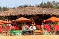 Two Indian tourists sitting at beach shack at the popular beach in Calangute