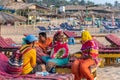 Women wearing colorful clothes sitting on a beach bed and having a cheerful conversation at Royalty Free Stock Photo