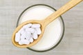 Calcium carbonate tablets above a glass of fresh milk Royalty Free Stock Photo