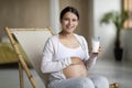 Calcium Drink. Smiling Pregnant Woman Holding Glass With Milk And Touching Belly