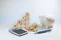 Calculate with variable interest, wooden cubes with the word rate and a percent sign, piggy bank, calculator and some coins on a Royalty Free Stock Photo