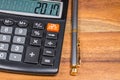 Calculator and ballpoint pen on wood table Royalty Free Stock Photo