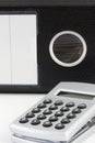 Calculator with black dossier on the background Royalty Free Stock Photo