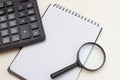 Calculator, blank note book and magnifier on a white background. Accountant Tools for Business Royalty Free Stock Photo