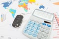 Calculator and car keys over world map Royalty Free Stock Photo