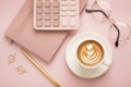 Calculator, a cup of coffee with a beautiful pattern and a notepad on a pink background. Place for text Royalty Free Stock Photo