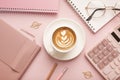 Calculator, a cup of coffee with a beautiful pattern and a notepad on a pink background. Place for text Royalty Free Stock Photo