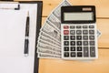 Calculator, dollars and a white sheet of paper. Close-up. View from above. Royalty Free Stock Photo