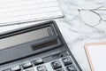 Calculator, keyboard and glasses on white marble table, closeup. Tax accounting Royalty Free Stock Photo
