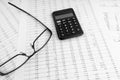 Calculator, keyboard, magnifying glass, eye glasses lying on financial documents. Top view Royalty Free Stock Photo