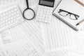 Calculator, keyboard, magnifying glass, eye glasses lying on financial statement. Top view Royalty Free Stock Photo