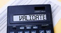 A calculator labeled VALIDATE is on the table near the report. Financial concept