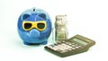 Calculator lies at blue piggy bank and dollar banknotes Royalty Free Stock Photo