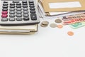 Calculator on notebook, pile of mail, coins and bank notes on white background. Royalty Free Stock Photo