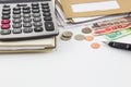 Calculator on notebook, pile of mail, coins and bank notes on white background. Royalty Free Stock Photo