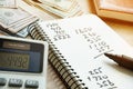 Calculator and notepad with calculations after counting money. Royalty Free Stock Photo