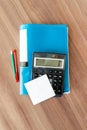 calculator pen and pencil and folder for documents lie on a wooden table. white sticker place for text. Accounting and audit.