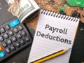 Calculator,pencil and banknotes with the word Payroll Deduction