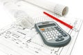 Calculator and pencil on house plan with rolls of architectural drawings Royalty Free Stock Photo