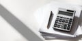 A calculator and a pencil on top of papers, with the shadow from an unseen window in the background Royalty Free Stock Photo