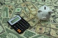 Calculator and piggy bank on a pile of ten dollar banknotes, Money background. Royalty Free Stock Photo