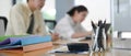 A calculator is putting on the wooden table surrounded by various office equipment. Royalty Free Stock Photo