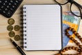 Calculator, rosary, coins, banknotes, book, spectacle and pen on wooden background Royalty Free Stock Photo