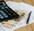 Calculator and Russian money on sheets of paper with numbers. Royalty Free Stock Photo