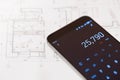 Calculator in smartphone and real estate plan Royalty Free Stock Photo