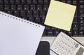 Calculator, smartphone and tablet on the laptop keyboard, close-up