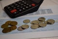 Calculator and the stack of coint isolated on office desk. calculating salary or tax concept Royalty Free Stock Photo