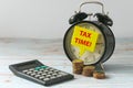 Calculator,stack of gold coins, vintage alarm clock with yellow speech bubbles written with Tax Time