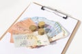 A calculator,stacks of coins and a euro banknotes on a white background