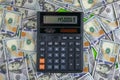 An calculator stand on a pile of dolar banknotes Royalty Free Stock Photo