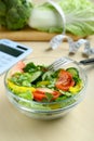 Calculator, tasty salad in bowl and other food on wooden table. Weight loss concept Royalty Free Stock Photo