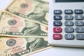 Calculator on ten dollars banknotes on a white background. Concept of Calculation of income and expenses