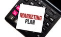 Calculator with text MARKETING PLAN with white paper