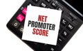 Calculator with text NET PROMOTER SCORE with white paper