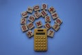 Calculator and a wooden number and mathematical symbol on blue background