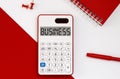 Calculator with the word BUSINESS on the display with red notepad and office tools Royalty Free Stock Photo