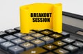 On the calculator is a yellow, twisted paper plate with the inscription - Breakout Session