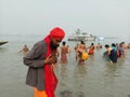 An Indian sadhu performing rituals of Makar Sankranti, the Ganges puja or worship in holy water Royalty Free Stock Photo