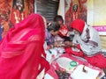 Yogi astrologer in his akhara or gangasagar yatra transit camp consulting astrology with female clients