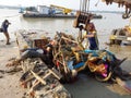 A worker tying the structure with crane after immerssion of Maa Kali and a photographer catching the pollution of the Ganges.